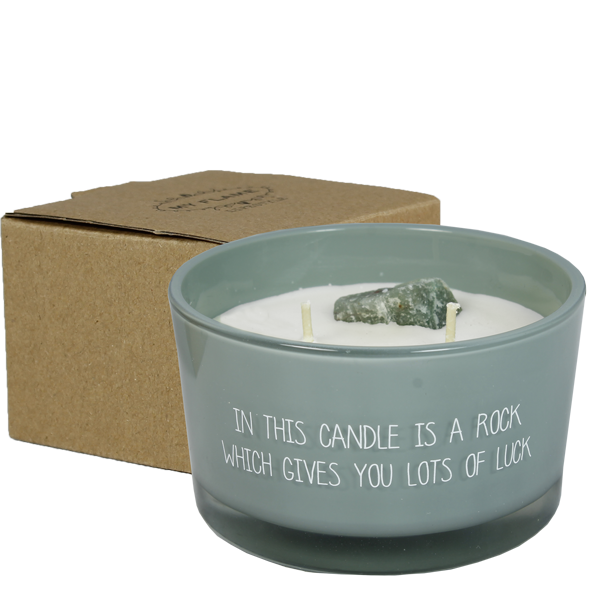 Bio Duftkerze aus Sojawachs und ein grüner Aventurin Kristall in einem grauen Glas mit weißer Beschriftung in this candle is a rock which gives you lots of luck. Eine Verpackung aus Kraftpapier.