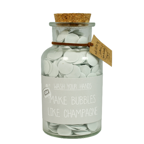Handseife. Eine durchsichtige Flasche mit Korkdeckel. Auf der Flasche ist eine Beschriftung make bubbles like champagne.