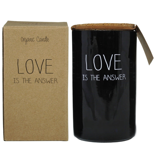 Bio Duftkerze Sojawachs mit warmem Kaschmir Duft in einem feuerfesten schwarzen Glas mit Korkdeckel und die Beschriftung "Love is the answer" und ihre Verpackung.
