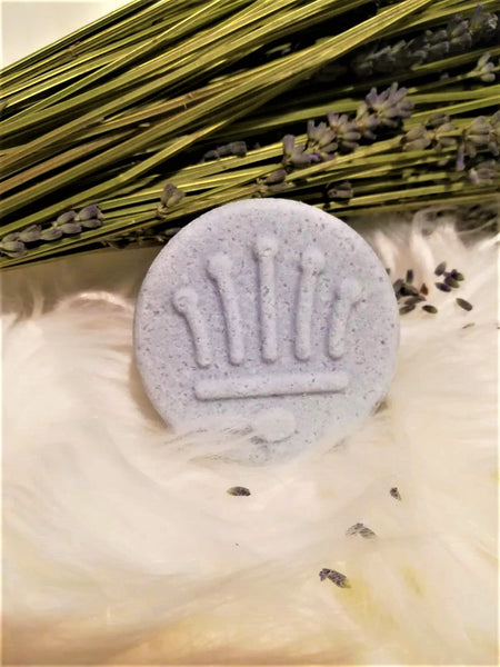 Ein Lavendel festes Shampoo neben einem Lavendelstrauß und auf weißem Fell.