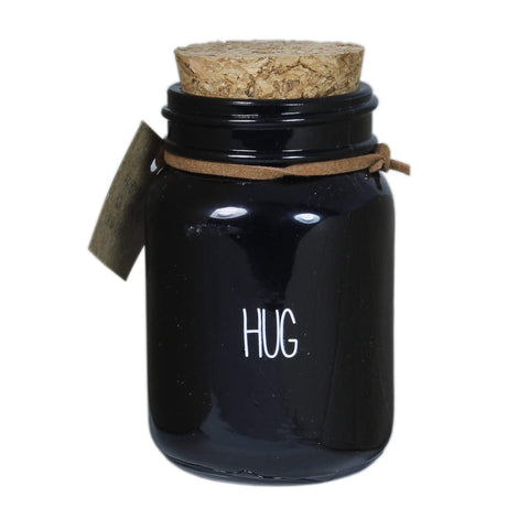 Bio Duftkerze Sojawachs mit warmem Kaschmir Duft in einem feuerfesten schwarzen Glas mit Korkdeckel und die Beschriftung "Hug".
