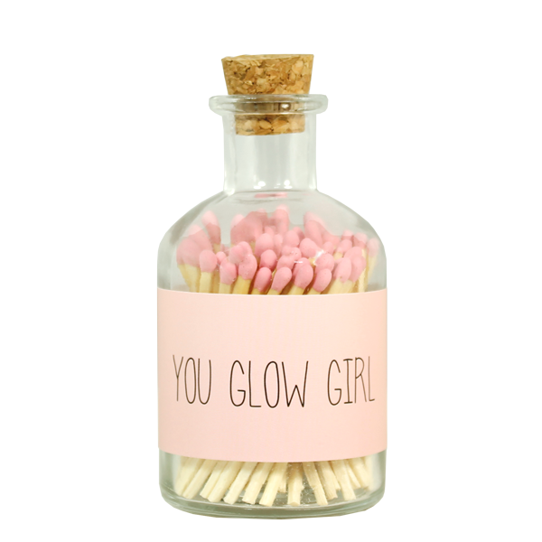 Streichhölzern rosa. Eine durchsichtige Flasche mit Korkdeckel. Auf der Flasche ist eine Beschriftung "You glow girl"