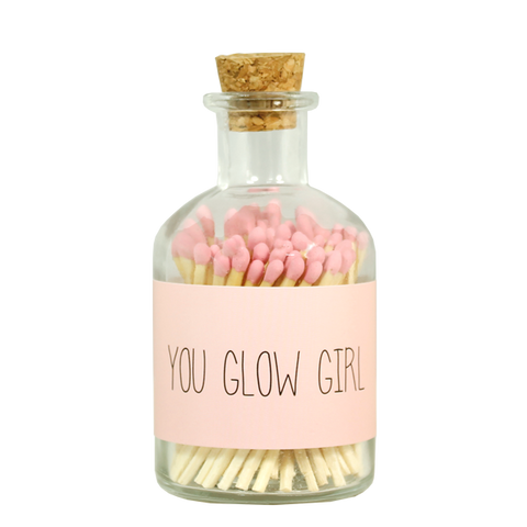 Streichhölzern rosa. Eine durchsichtige Flasche mit Korkdeckel. Auf der Flasche ist eine Beschriftung "You glow girl"