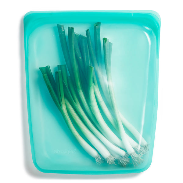 Wiederverwendbarer Behälter mit Frühlingszwiebeln gefüllt - Stasher bag - aus Silikon in Aqua Farbe - Large.