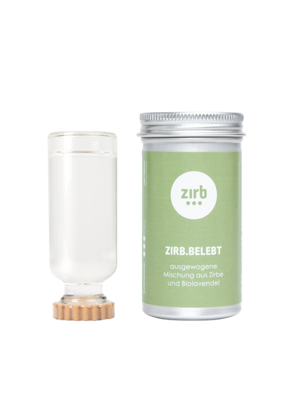 Eine Flasche Zirbenöl mit braunem Deckel und eine metalische Dose, eine grüne Etikette mit der Beschriftung ZIRB:BELEBT.